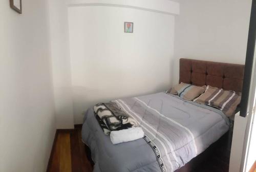 1 dormitorio con 1 cama con cabecero marrón en Cusco Central Aparment en Cuzco