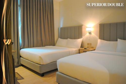 ein Hotelzimmer mit 2 Betten und einem Avisorvisor in der Unterkunft West Prime Hotel in Calbayog