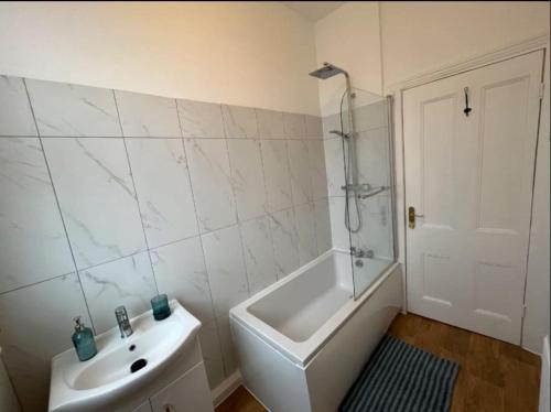 a white bathroom with a sink and a shower at Two Bedroom Flat in London in London