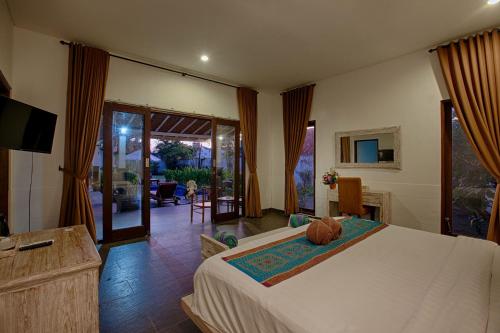 a bedroom with a bed and a television in it at My Villa and Resort Canggu in Canggu