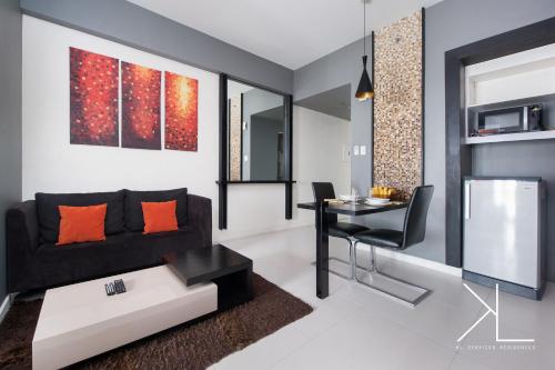 a living room with a black couch and a table at KL Serviced Residences Managed by HII in Manila