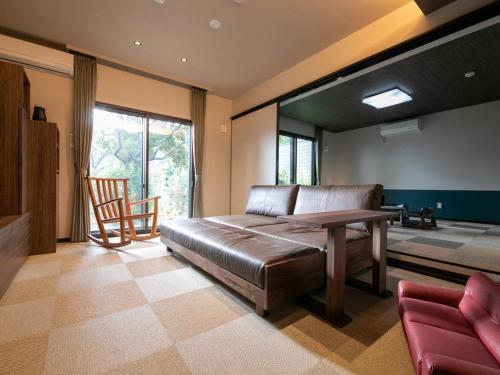 1 dormitorio con 1 cama, mesa y sillas en Bettei Fujiya, en Miyajima