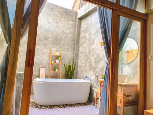 清康的住宿－นา-ใบบุญ Nabaiboon，一间带大浴缸和水槽的浴室