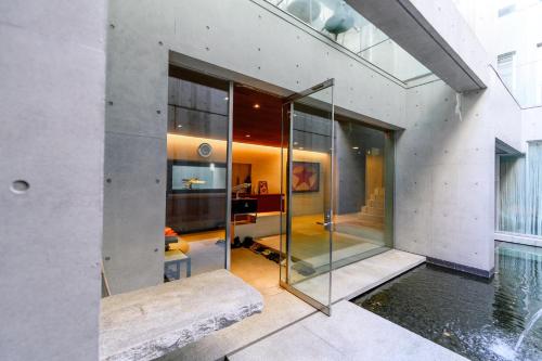 a glass pivot door in a house with a pool at Azabu Modern House in Tokyo