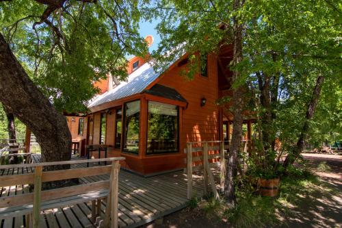 a cabin in the woods with a wooden deck at Cabañas Tronco Mayen in Las Trancas