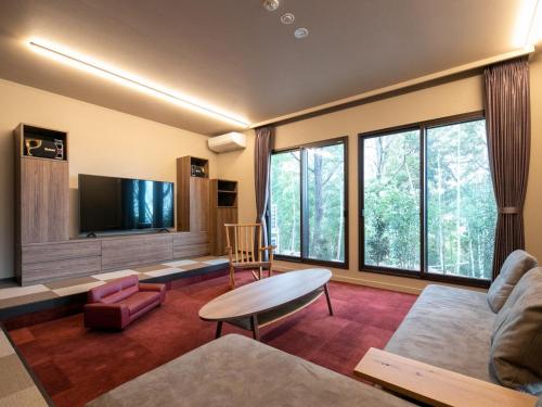 a living room with a couch and a tv at Bettei Fujiya in Miyajima