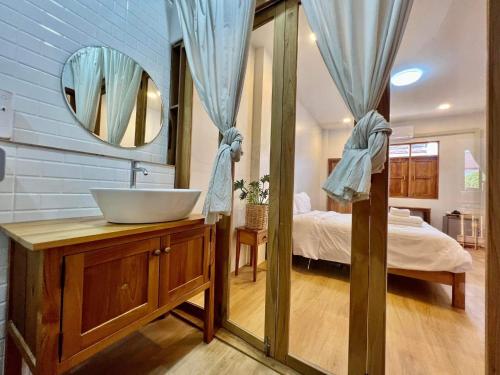 La salle de bains est pourvue d'un lavabo, d'un lit et d'un miroir. dans l'établissement นา-ใบบุญ Nabaiboon, à Chiang Khan