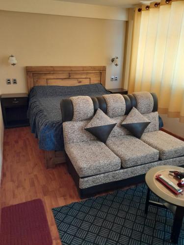 ein Wohnzimmer mit einem Sofa und einem Bett in der Unterkunft Hostal Nichkito in Uyuni