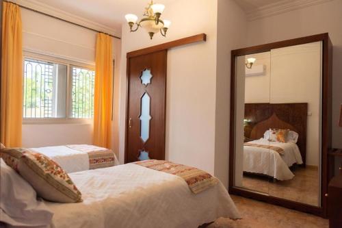 um quarto com 2 camas e um espelho grande em VILLA MATI Maison D'hôtes em Tétouan
