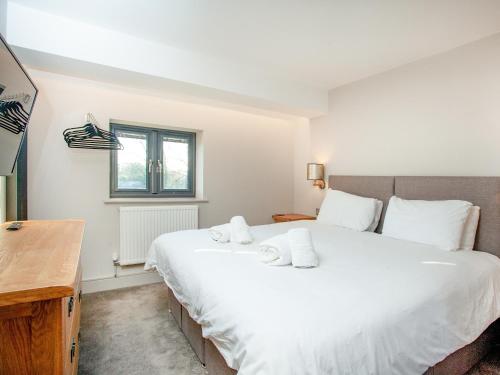 Schlafzimmer mit einem großen weißen Bett und einem Schreibtisch in der Unterkunft The Cowrie in Turnchapel
