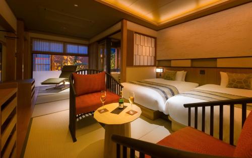 a hotel room with two beds and a chair at Onomichi Hansei in Onomichi