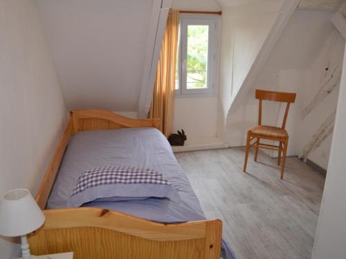 1 dormitorio con 1 cama, 1 silla y 1 ventana en Gîte Nazelles-Négron, 3 pièces, 3 personnes - FR-1-381-7, en Montreuil-en-Touraine