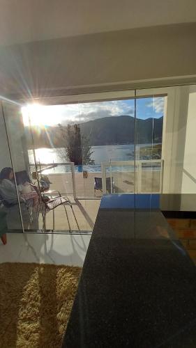 a living room with a view of a beach and the ocean at Paraíso da Enseada de Brito in Palhoça
