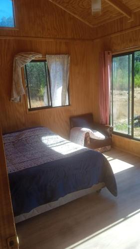 - une chambre avec un lit, un canapé et des fenêtres dans l'établissement Cabaña peumayen, à Juan Chico