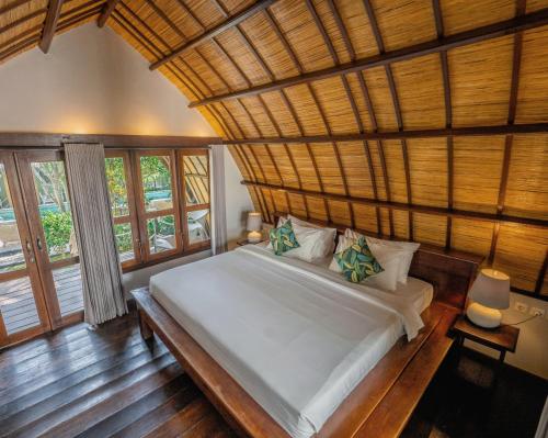 ギリ・トラワンガンにあるマンタ ダイブ ギリ トラワンガン リゾートの木製の天井のベッドルーム1室(大型ベッド1台付)