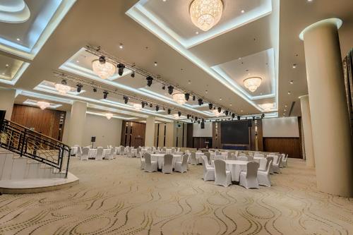 a banquet hall with white tables and white chairs at Makkah Al Aziziah in Makkah