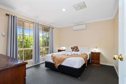 1 dormitorio con cama y ventana grande en Bea-Vic Home. Your home away from home., en Kalgoorlie
