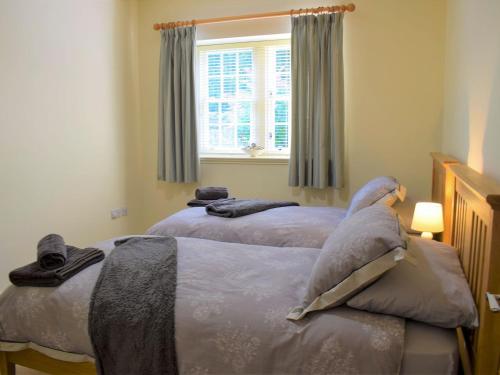 two twin beds in a bedroom with a window at The Old Frame House in Rock