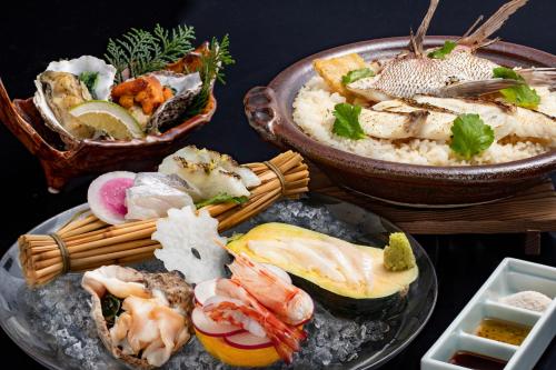 una mesa con dos platos de marisco y arroz en Onomichi Hansei, en Onomichi