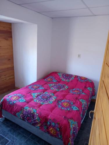 1 dormitorio con edredón rojo en la cama en SAN CARLOS Apart en La Consulta