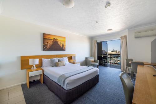 a hotel room with a bed and a desk and a table at Aligned Corporate Residences Townsville in Townsville