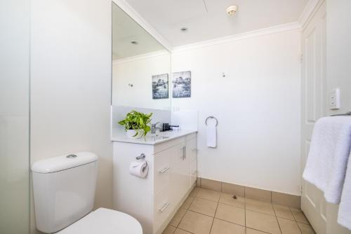 a white bathroom with a toilet and a sink at Aligned Corporate Residences Townsville in Townsville