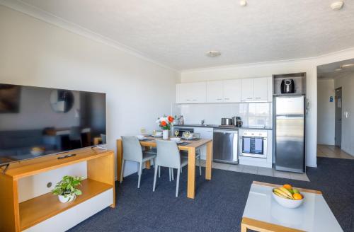 a kitchen with a table and a dining room at Aligned Corporate Residences Townsville in Townsville