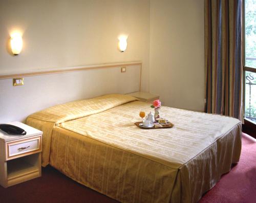 una camera d'albergo con un letto e un vassoio di cibo sopra di Hotel Adler a Milano