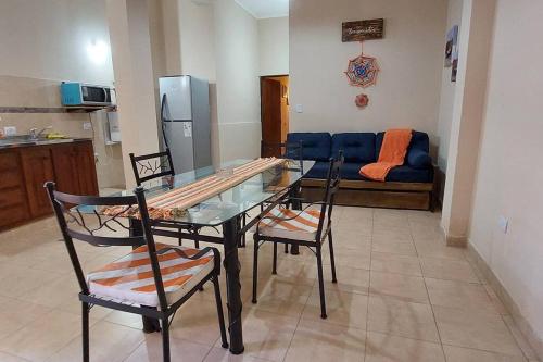 sala de estar con mesa de cristal, sillas y sofá en Depto. céntrico en CatamarcaCity en San Fernando del Valle de Catamarca