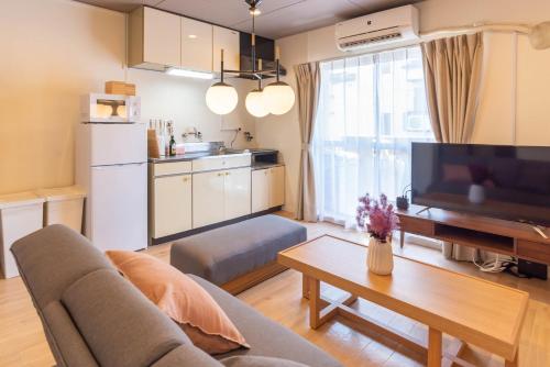 salon z kanapą, telewizorem i stołem w obiekcie Mansion Hashimoto - Vacation STAY 7764 w Osace