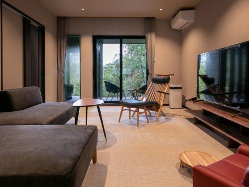 a living room with a large flat screen tv at Bettei Fujiya in Miyajima