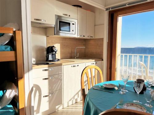 une cuisine avec une table recouverte d'une nappe dans l'établissement Studio lumineux 4 couchages près de la plage avec options linge et Wifi - FR-1-251-433, au Lavandou