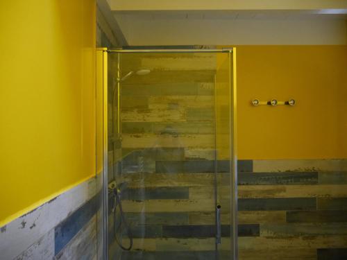 a glass shower in a bathroom with yellow walls at Maison Bangor, 3 pièces, 4 personnes - FR-1-418-215 in Bangor