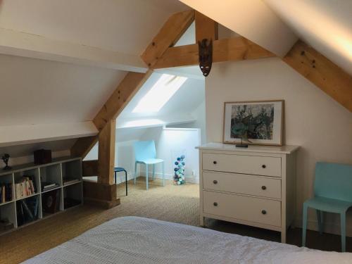 a attic bedroom with a bed and a dresser and chairs at Appartement Le Palais, 2 pièces, 4 personnes - FR-1-418-219 in Le Palais