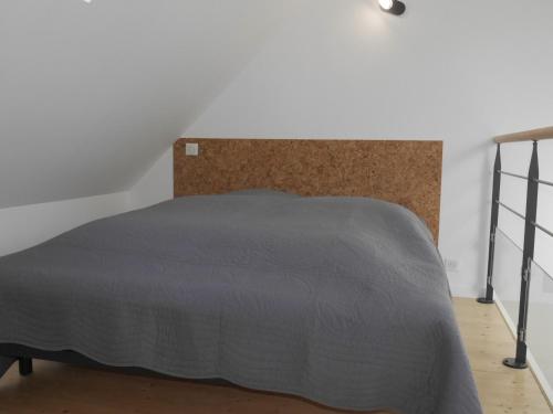 ein Schlafzimmer mit einem Bett mit einer grauen Decke in der Unterkunft Maison Locmaria, 2 pièces, 2 personnes - FR-1-418-223 in Locmaria
