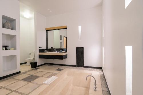 The Seminyak Suite - Private Villa في سمينياك: حمام مع حوض وحوض استحمام