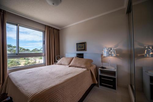 - une chambre avec un lit et une grande fenêtre dans l'établissement Ocean Drive by depptö, à Punta del Este