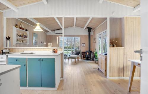 a kitchen with blue cabinets and a dining room at Pet Friendly Home In Otterup With Wifi in Otterup