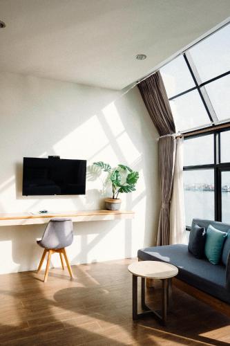 a living room with a blue couch and a desk at Baan Tah On The Sea in Bang Sare
