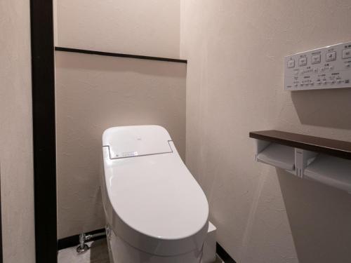 a bathroom with a white toilet in a stall at Bettei Fujiya in Miyajima