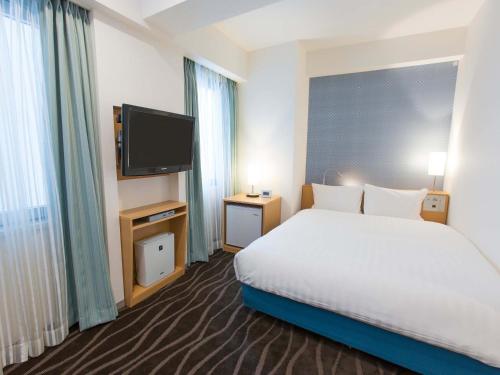 a hotel room with a bed and a flat screen tv at Shibuya Tobu Hotel in Tokyo