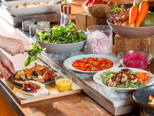 a buffet with plates of food on a table at GOOD NATURE HOTEL KYOTO in Kyoto