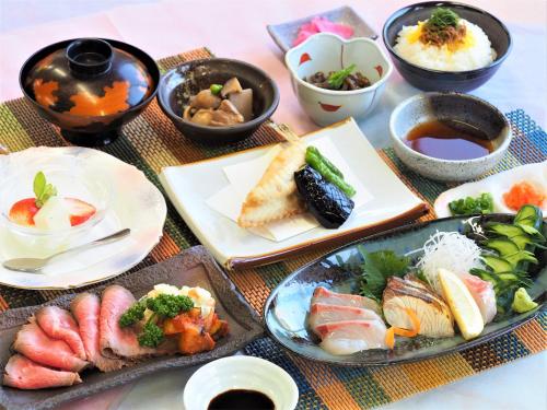 uma mesa com pratos e tigelas de comida em Le Port Awashima em Mitoyo