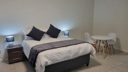 a bedroom with a bed with a table and chairs at The Aura in Roodepoort