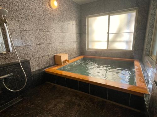 a bathroom with a bath tub with a window at Little Grebe in Chino