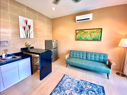 sala de estar con sofá azul y lavamanos en The Paddy Field - Private Pool Villas en Pantai Cenang