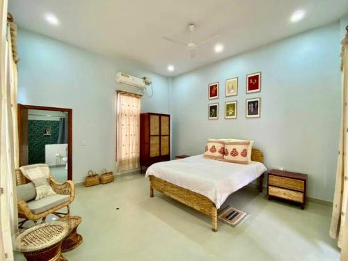 a bedroom with a bed and a chair at Jetuka - Villa in Sibsagar in Sivasagar