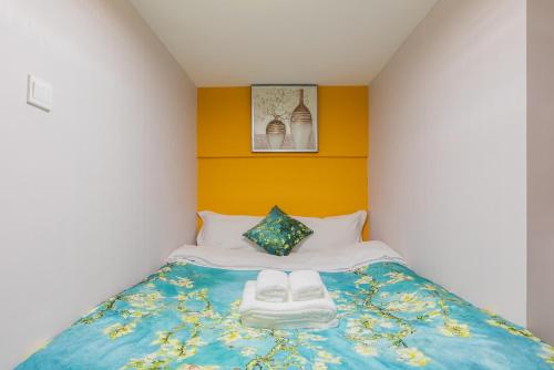 a bedroom with a bed with two towels on it at Lavendar Duplex Apartment in Guangzhou