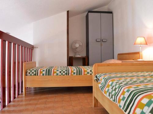 une chambre avec deux lits et un placard dans l'établissement Pavillon 2 pièces + mezzanine, piscine, proche plage, quartier calme - 6 pers. - FR-1-229D-320, à Saint Pierre La Mer