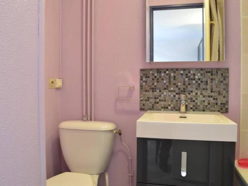 une salle de bains rose avec toilettes et lavabo. dans l'établissement Pavillon 2 pièces + mezzanine, piscine, proche plage, quartier calme - 6 pers. - FR-1-229D-320, à Saint Pierre La Mer